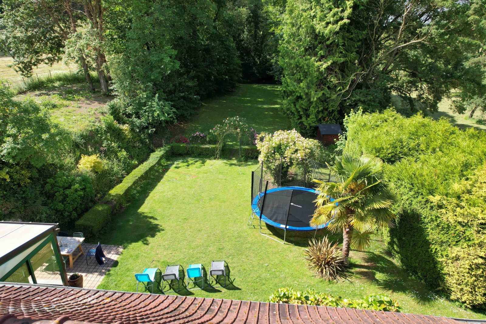 De grote trampoline achter in de tuin
